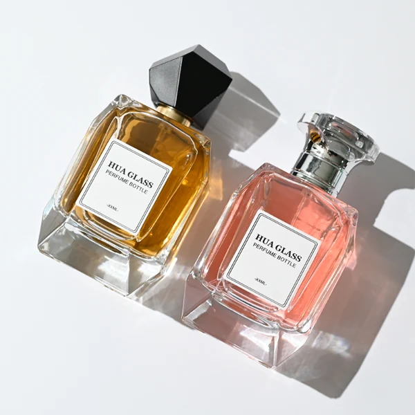 HUA0312 perfume bottle, transparent colorless multifaceted angular-cut glass body with thick geometric base, 100 ml liquid, multifaceted spherical or layered bowl-shaped plastic cap with gold bottle neck, printed label attached on bottle surface, elegant modern luxury design, ideal for gifting and daily use.