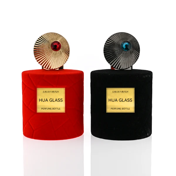HUA0313 perfume bottle, cylindrical velvet-textured glass body in red or black color, 50 ml or 100 ml liquid, circular Zamac cap with sunburst texture and gemstone detail, aluminum labelsticker attached on bottle surface, artistic luxury vintage design, ideal for gifting and daily use.