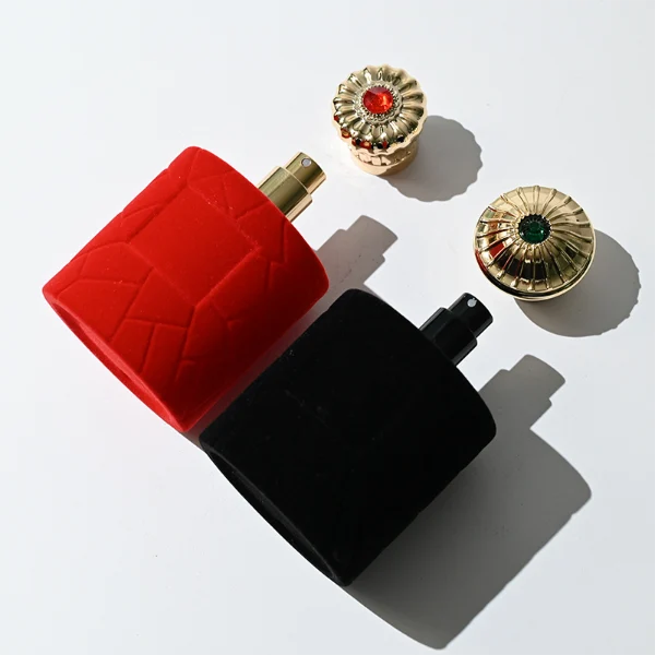 HUA0313 perfume bottle, cylindrical velvet-textured glass body in red or black color, 50 ml or 100 ml liquid, circular Zamac cap with sunburst texture and gemstone detail, aluminum labelsticker attached on bottle surface, artistic luxury vintage design, ideal for gifting and daily use.