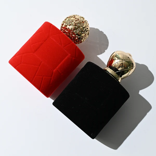HUA0313 perfume bottle, cylindrical velvet-textured glass body in red or black color, 50 ml or 100 ml liquid, circular Zamac cap with sunburst texture and gemstone detail, aluminum labelsticker attached on bottle surface, artistic luxury vintage design, ideal for gifting and daily use.