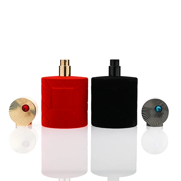 HUA0313 perfume bottle, cylindrical velvet-textured glass body in red or black color, 50 ml or 100 ml liquid, circular Zamac cap with sunburst texture and gemstone detail, aluminum labelsticker attached on bottle surface, artistic luxury vintage design, ideal for gifting and daily use.