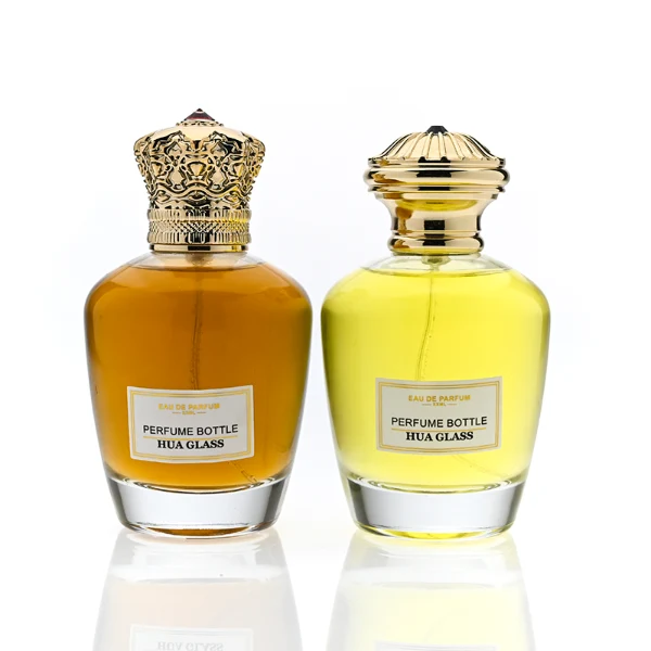HUA0314 perfume bottle, rounded transparent colorless glass body with thick base and smooth curved silhouette, 100 ml liquid, ornamental Zamak cap with carved crown-inspired or layered dome design in glossy gold finish, printed label attached on bottle surface, vintage royal luxury design, ideal for gifting and daily use.