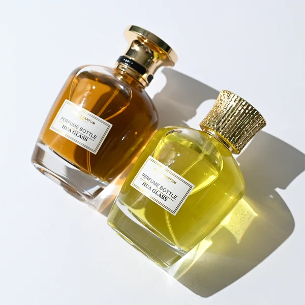 HUA0314 perfume bottle, rounded transparent colorless glass body with thick base and smooth curved silhouette, 100 ml liquid, ornamental Zamak cap with carved crown-inspired or layered dome design in glossy gold finish, printed label attached on bottle surface, vintage royal luxury design, ideal for gifting and daily use.