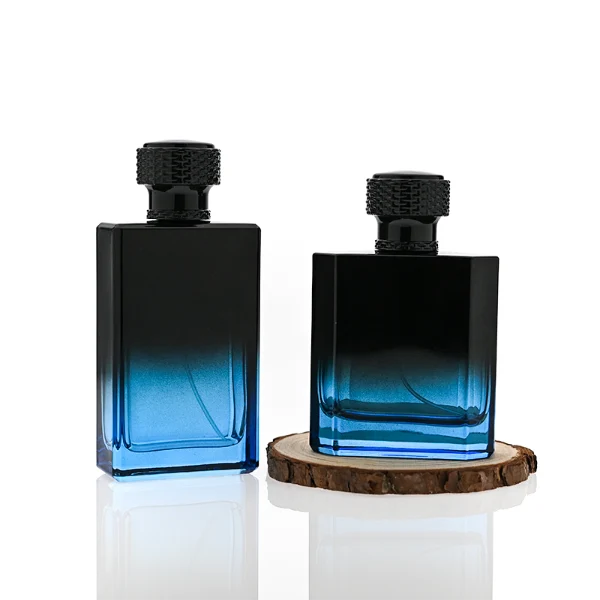 HUA0315 perfume bottle, rectangular semi-transparent glass body with blue-to-black gradient color, thick base and sharp edges, 50 ml or 100 ml liquid, textured cylindrical black plastic cap with layered neck detail, aluminum label/sticker attached on bottle surface, modern masculine luxury design, ideal for gifting and daily use.