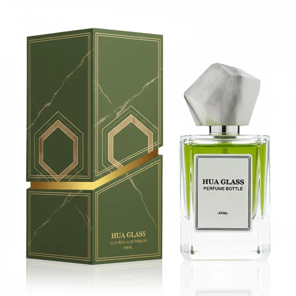 HUA0322 perfume bottle, square transparent colorless glass body with thick base and sharp edges, 30 ml, 50 ml, or 100 ml liquid, irregular geometric stone-inspired plastic cap in beige or marble white color with gold or silver bottle neck, printed label attached on bottle surface, artistic modern luxury design, ideal for gifting and daily use.