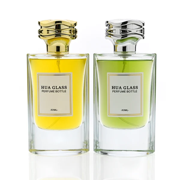 HUA0327 perfume bottle, minimalist geometric cylindrical transparent glass body with smooth curved sides and thick base, 80 ml liquid, irregular geometric plastic cap with side wave-texture in glossy gold or silver finish, printed label on bottle surface, modern minimalist luxury design, ideal for gifting and daily use.