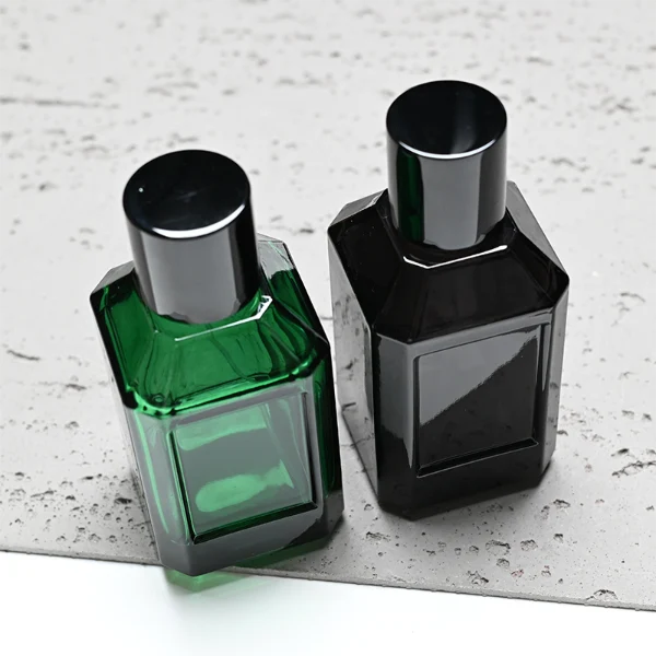 HUA0330 perfume bottle, multifaceted semi-transparent black or green glass body with polyhedral faceted cutting and thick base, 35 ml, 50 ml, or 100 ml liquid, glossy black cylindrical cap, clean blank bottle surface, modern geometric luxury design, ideal for gifting and daily use.