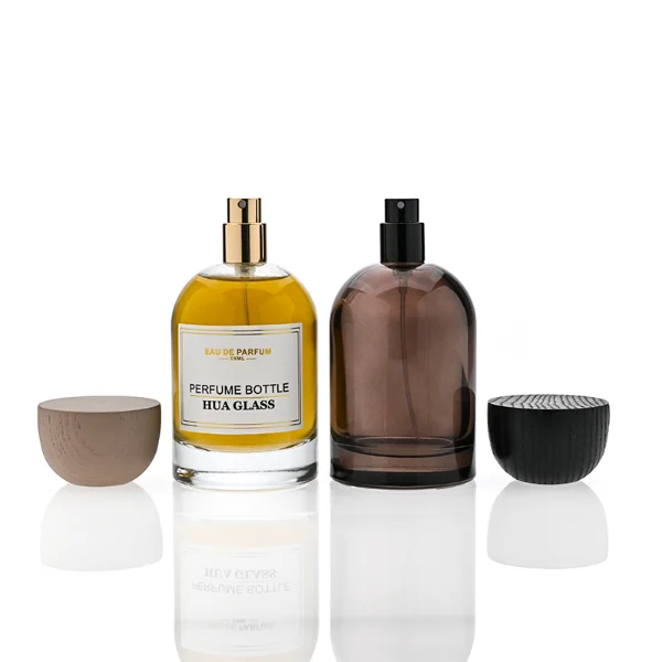 HUA0331 perfume bottle, rounded cylindrical transparent or semi-transparent smoky brown glass body with thick base, 30 ml, 50 ml, or 100 ml liquid, semi-spherical wooden cap in natural wood or black color, gold bottle neck, printed label or blank bottle surface, modern natural luxury design, ideal for gifting and daily use.