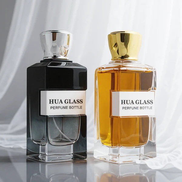 HUA0332 perfume bottle, rectangular semi-transparent gradient black or transparent colorless glass body with smooth curved edges and thick base, 100 ml liquid, rounded square-shaped glossy plastic cap in gold or silver finish, brand logo label attached on bottle surface, modern geometric luxury design, ideal for gifting and daily use.