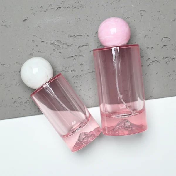 HUA0333 perfume bottle, rounded cylindrical frosted glass body in white, pink, lavender, or light blue, 30 ml, 50 ml, or 100 ml liquid, spherical resin cap with marble-inspired texture, silver bottle neck, gold printed brand logo on bottle surface, modern pastel luxury design, ideal for gifting and daily use.