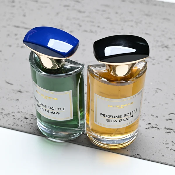 HUA0334 perfume bottle, minimalist geometric cylindrical transparent colorless glass body, 50 ml liquid, irregular geometric plastic cap with square bowl-shaped base and black or dark navy top block, no bottle neck, brand logo label attached on bottle surface, modern artistic luxury design, ideal for gifting and daily use.