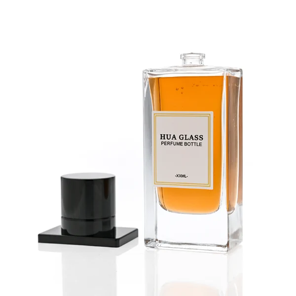 HUA0336 perfume bottle, rectangular transparent colorless glass body with thick base, 100 ml liquid, T-shaped aluminum and magnetic cap with cylindrical upper structure and horizontal flat top in black or gold finish, label attached on bottle surface, modern minimalist luxury design, ideal for gifting and daily use.