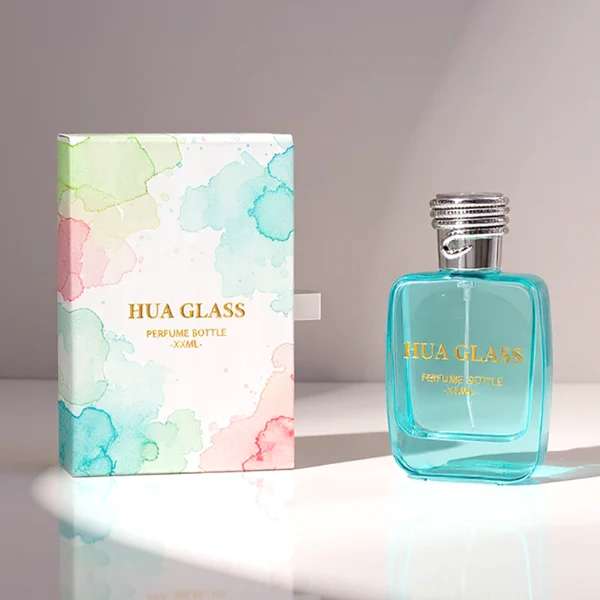 HUA0337 perfume bottle, rounded rectangular transparent colorless glass body with light blue tint, 50 ml or 100 ml liquid, silver cylindrical plastic cap with rope-inspired decorative detail, silver bottle neck, gold printed brand logo on bottle surface, modern minimalist luxury design, ideal for gifting and daily use.
