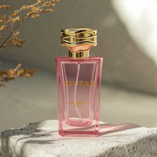 HUA0338 perfume bottle, rectangular transparent pink glass body with curved inner contour and thick base, 100 ml liquid, irregular geometric plastic cap with wave-pattern side texture in gold or silver finish, matching metallic bottle neck, clean bottle surface for logo printing or label application, elegant feminine luxury design, ideal for gifting and daily use.