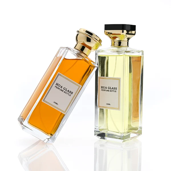 HUA0339 perfume bottle, tall rectangular transparent colorless glass body with beveled edges and thick base, 200 ml liquid, flat-top geometric plastic cap in glossy black or gold finish with layered cylindrical base, no bottle neck, brand logo label on bottle surface, modern luxury minimalist design, ideal for gifting and daily use.