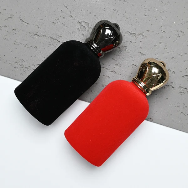 HUA0340 perfume bottle, rounded cylindrical glossy black or red glass body covered in velvet with thick base, 30 ml, 50 ml, or 100 ml liquid, crown-shaped Zamak cap with faceted rhombus-cut pattern in matching glossy black or red, black or gold bottle neck matching cap, gold printed brand logo on velvet surface, modern royal luxury design, ideal for gifting and daily use.