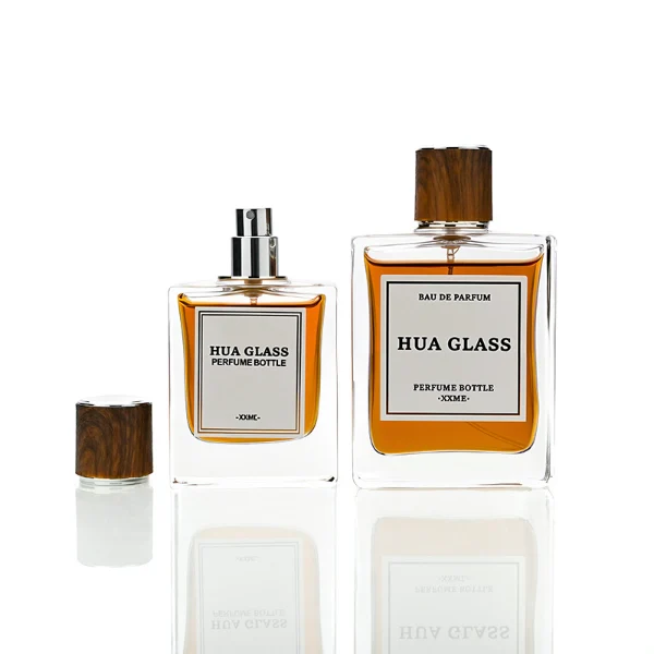 HUA0260 perfume bottle, rectangular transparent glass body with clean straight edges and thick base, 50 ml or 100 ml liquid, cylindrical wood-grain plastic cap with smooth surface and silver bottle neck, printed logo label, modern minimalist luxury design, ideal for gifting and daily use.