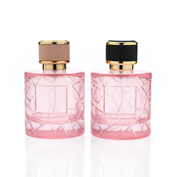 HUA0342 perfume bottle, cylindrical transparent pink glass body with fragmented surface texture, 50 ml or 100 ml liquid, gold plastic cap with textured pink or black side surface and glossy gold top, gold bottle neck, aluminum brand label attached on bottle surface, modern feminine luxury design, ideal for gifting and daily use.