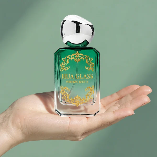 HUA0343 perfume bottle, rectangular semi-transparent blue, pink, amber, or smoky black glass body with beveled edges and thick base, 30 ml, 50 ml, or 100 ml liquid, glossy black spherical plastic cap with smooth polished surface, black bottle neck, gold printed brand logo on bottle surface, modern artistic luxury design, ideal for gifting and daily use.