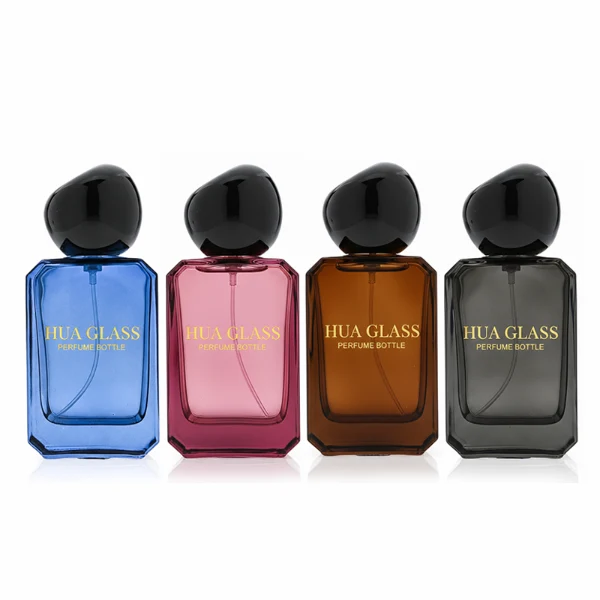 HUA0343 perfume bottle, rectangular semi-transparent blue, pink, amber, or smoky black glass body with beveled edges and thick base, 30 ml, 50 ml, or 100 ml liquid, glossy black spherical plastic cap with smooth polished surface, black bottle neck, gold printed brand logo on bottle surface, modern artistic luxury design, ideal for gifting and daily use.