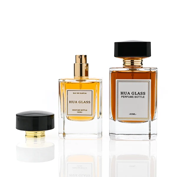 HUA0344 perfume bottle, rectangular transparent colorless glass body with beveled edges and thick base, 30 ml, 50 ml, or 100 ml liquid, wide glossy black cylindrical plastic cap with convex top and flat sides, gold screw-type bottle neck, brand logo label attached on bottle surface, modern minimalist luxury design, ideal for gifting and daily use.