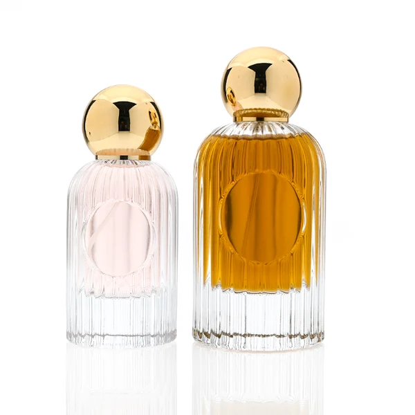 HUA0345 perfume bottle, cylindrical transparent colorless glass body with vertical ribbed texture, 50 ml or 100 ml liquid, spherical glossy gold plastic cap with magnetic closure, gold bottle neck, gold aluminum label attached on bottle surface, elegant luxury design, ideal for gifting and daily use.