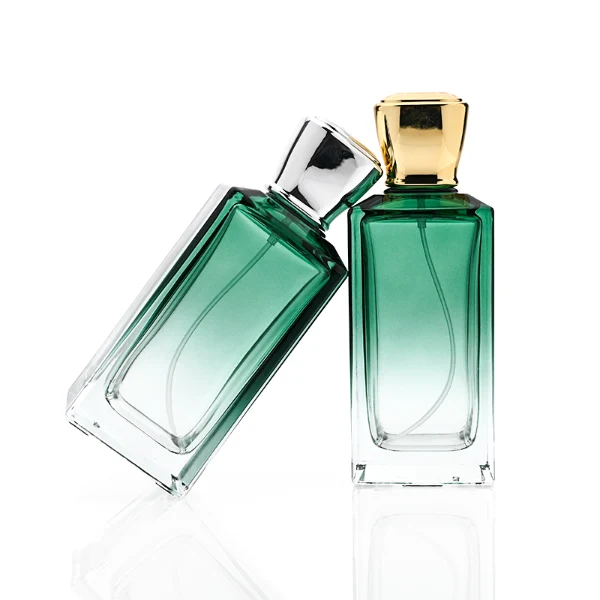 HUA0346 perfume bottle, rectangular transparent colorless glass body with gradient blue, green, or amber tint, 100 ml liquid, glossy square plastic cap with smooth curved sides, no bottle neck, gold printed brand logo on bottle surface, modern luxury minimalist design, ideal for gifting and daily use.