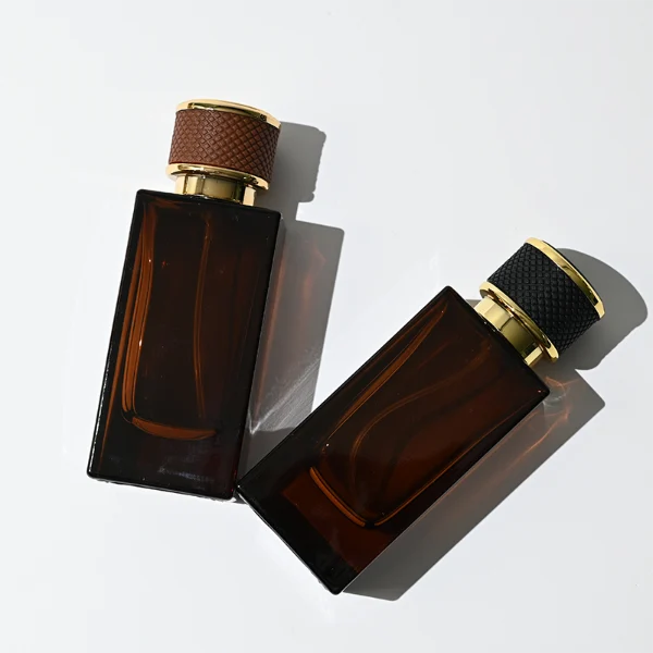 HUA0347 perfume bottle, rectangular amber glass body with thick base and smooth beveled edges, gold plastic cap wrapped in black or brown leather, luxury minimalist fragrance packaging design, ideal for gifting and personal fragrance use