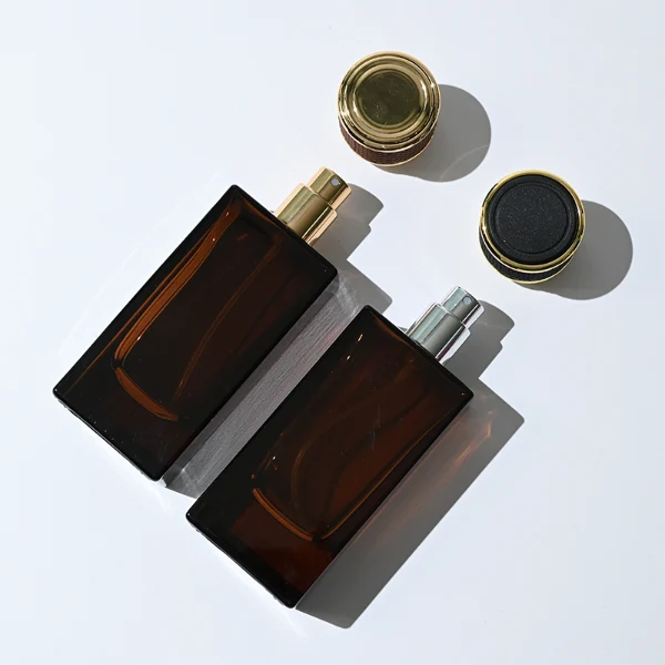 HUA0347 perfume bottle, rectangular amber glass body with thick base and smooth beveled edges, gold plastic cap wrapped in black or brown leather, luxury minimalist fragrance packaging design, ideal for gifting and personal fragrance use