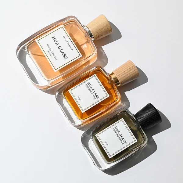 HUA0348 perfume bottle, rounded rectangular clear glass body with thick base, tapered wooden cap available in black, brown, or natural wood color, optional gold or silver collar, modern minimalist luxury fragrance packaging design