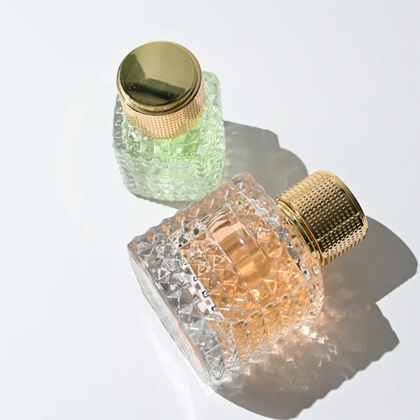 HUA0349 perfume bottle, embossed round clear glass body with aluminum label plate, layered ring edge details, textured metallic cylindrical cap, luxury vintage fragrance packaging design