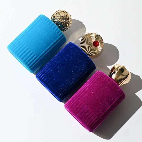 HUA0351 perfume bottle, velvet wrapped cylindrical glass body with gold aluminum label plate, decorative metallic zamak cap with sunburst texture or irregular cylindrical shape, luxury artistic vintage fragrance packaging design