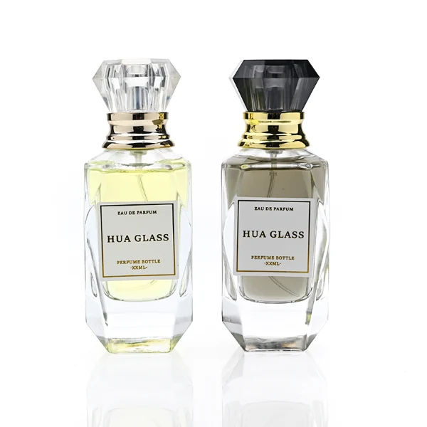 HUA0352 perfume bottle, multi-faceted geometric cut glass body with clear or black diamond-shaped plastic cap and gold collar, minimalist paper label with elegant gold lettering, modern luxury fragrance packaging design