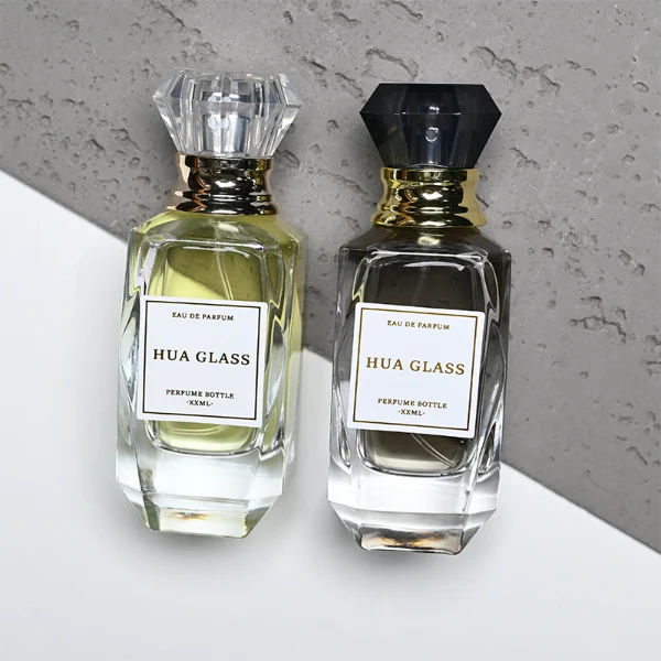 HUA0352 perfume bottle, multi-faceted geometric cut glass body with clear or black diamond-shaped plastic cap and gold collar, minimalist paper label with elegant gold lettering, modern luxury fragrance packaging design