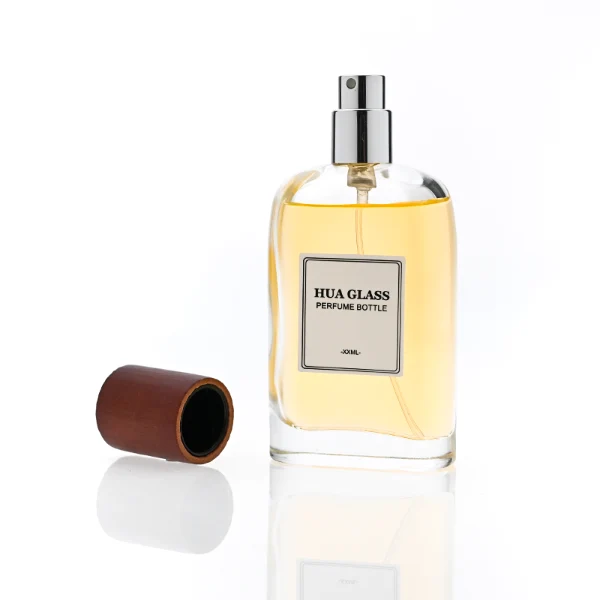 HUA0353 perfume bottle, flat cylindrical glass body with reddish-brown or black cylindrical wooden cap, square paper label with minimalist border, Nordic minimalist fragrance packaging design available in 50ml and 75ml