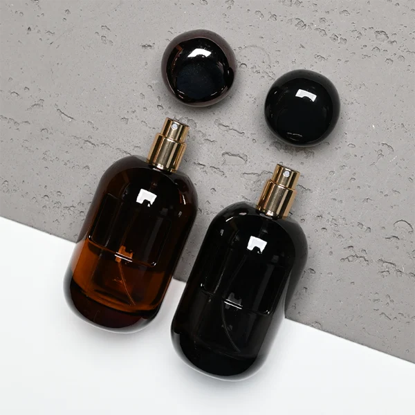 HUA0355 perfume bottle, colored cylindrical glass body in amber brown, purple, and burgundy red with gold aluminum label plate, irregular sculptural pebble plastic cap, luxury artistic vintage fragrance packaging design