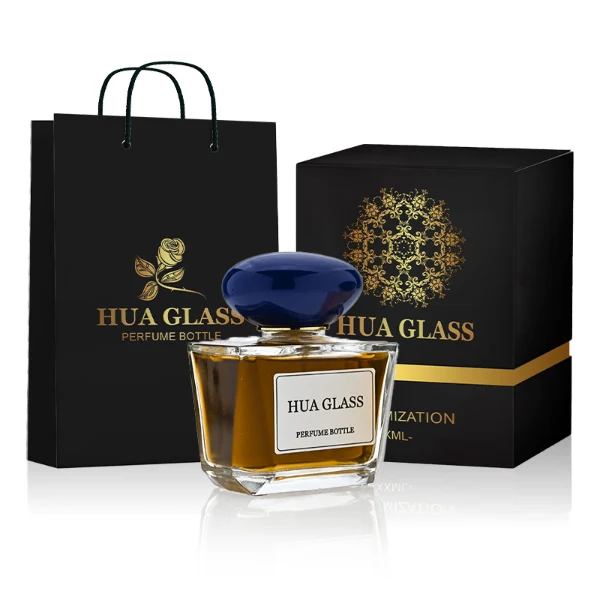 HUA0359 perfume bottle, low rectangular clear glass body with gold neck and a paper label attached, smooth oval pebble plastic cap in navy blue, white, or burgundy, contemporary artistic luxury fragrance packaging design available in 50ml and 100ml