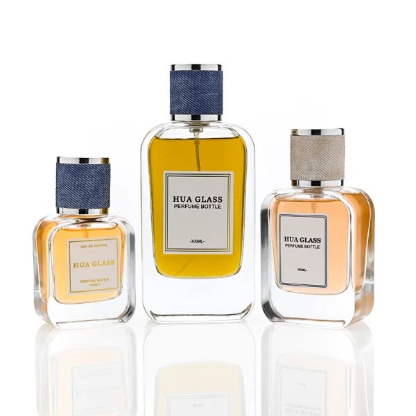 HUA0360 perfume bottle, flat rectangular clear glass body with silver neck and a paper label attached, textured blue or beige cylindrical plastic cap with silver trim, contemporary casual luxury fragrance packaging design available in 30ml, 50ml, and 100ml