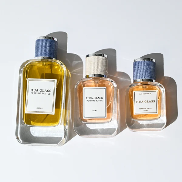 HUA0360 perfume bottle, flat rectangular clear glass body with silver neck and a paper label attached, textured blue or beige cylindrical plastic cap with silver trim, contemporary casual luxury fragrance packaging design available in 30ml, 50ml, and 100ml