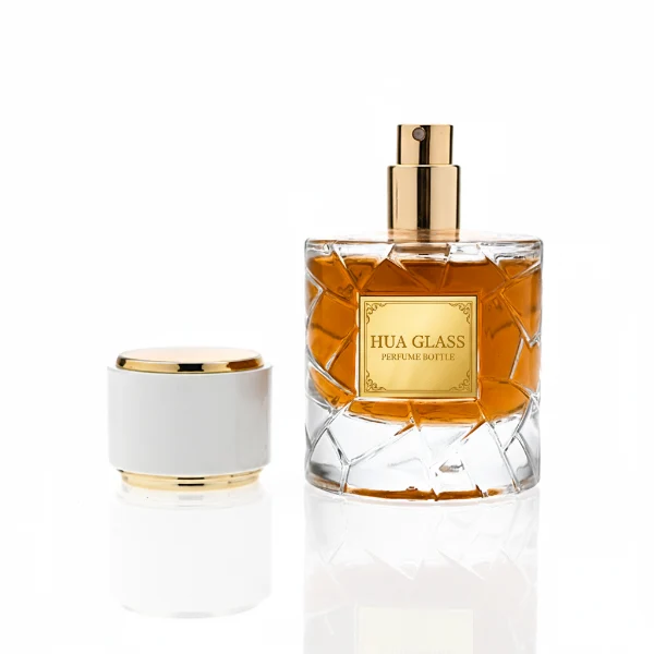 HUA0362 perfume bottle, textured ice-crack cylindrical clear glass body with gold neck and gold aluminum label, straight cylindrical white plastic cap with luxury gold trim, modern artistic luxury fragrance packaging design available in 50ml and 100ml