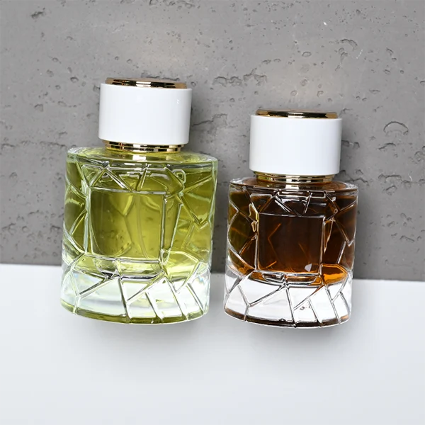 HUA0362 perfume bottle, textured ice-crack cylindrical clear glass body with gold neck and gold aluminum label, straight cylindrical white plastic cap with luxury gold trim, modern artistic luxury fragrance packaging design available in 50ml and 100ml