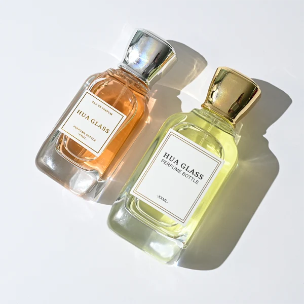 HUA0363 perfume bottle, flat rectangular clear glass body with centered paper label, elegant trophy-shaped plastic cap in gold or silver finish, royal classic luxury fragrance packaging design available in 50ml and 100ml