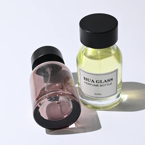 HUA0364 perfume bottle, round cylindrical glass body in translucent grey, red, and blue with gold printed logo, matte black inverted cone plastic cap, contemporary minimalist luxury fragrance packaging design available in 50ml and 100ml