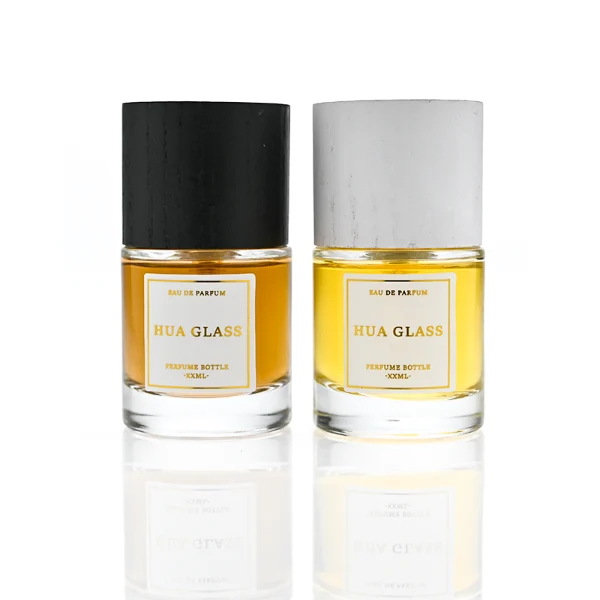 HUA0370 perfume bottle, cylindrical clear glass body with centered paper label, silver neck and silver pump, straight cylindrical wooden cap in matte black or light white natural wood grain texture, eco-friendly modern luxury fragrance packaging design available in 30ml, 50ml, and 100ml