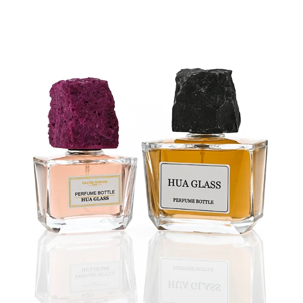 HUA0373 perfume bottle, wide rectangular cuboid clear glass body with centered paper label, rugged organic raw semi-precious stone cap in violet crystal, colorful agate or charcoal black rock textures, artistic luxury fragrance packaging design available in 50ml and 100ml