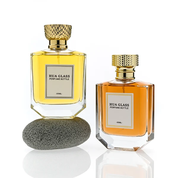 HUA0374 perfume bottle, flat hexagonal multi-faceted clear glass body with gold neck and centered paper label, textured inverted trapezoid gold plastic cap in grid knurled or chevron ribbed patterns matching the gold neck, Art Deco luxury fragrance packaging design in 100ml