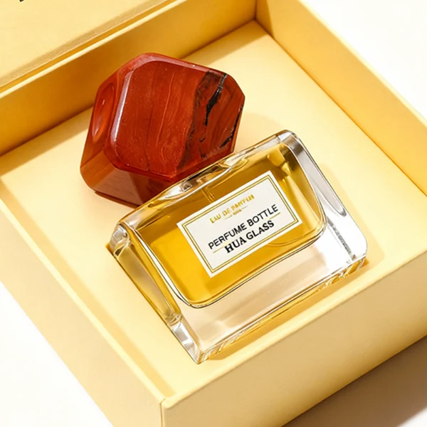 HUA0375 perfume bottle, wide rectangular cuboid clear glass body with centered paper label, oversized multi-faceted geometric semi-precious stone cap in jade green and reddish-brown tiger's eye gemstone textures, Zen luxury organic fragrance packaging design in 50ml