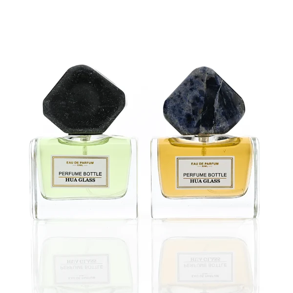 HUA0375 perfume bottle, wide rectangular cuboid clear glass body with centered paper label, oversized multi-faceted geometric semi-precious stone cap in jade green and reddish-brown tiger's eye gemstone textures, Zen luxury organic fragrance packaging design in 50ml