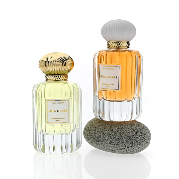 HUA0376 perfume bottle, vertical fluted clear glass body with diagonal twisted gold neck and centered paper label, swirling textured pumpkin-shaped plastic cap in shiny gold with black lines or matte white, neoclassical luxury fragrance packaging design available in 50ml and 100ml
