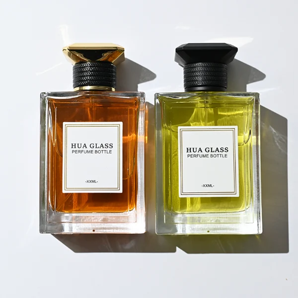 HUA0381 perfume bottle, flat rectangular cuboid clear glass body with horizontally ribbed black neck collar and centered paper label, geometric bi-conical UFO-shaped plastic cap in radiant gold or matte black, architectural luxury fragrance packaging design in 100ml